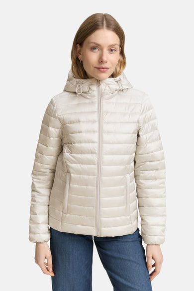 Veste courte grise de Tom Tailor, avec capuche, fermeture éclair centrale, portée avec un jean bleu.