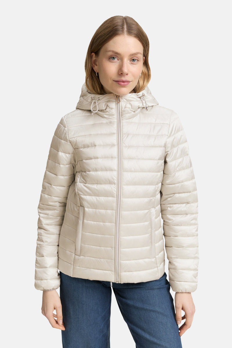 Veste courte grise de Tom Tailor, avec capuche, fermeture éclair centrale, portée avec un jean bleu.