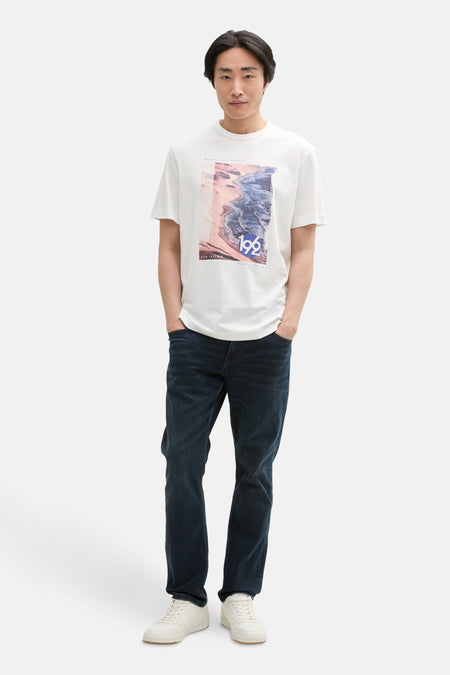 Wit T-shirt met korte mouwen van Tom Tailor, met een decoratieve print op de voorkant, gedragen met een spijkerbroek en witte schoenen.