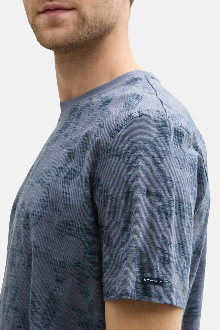 Blauw T-shirt met korte mouwen van Tom Tailor, subtiel textuurpatroon, logo-detail op de mouw, zijaanzicht.