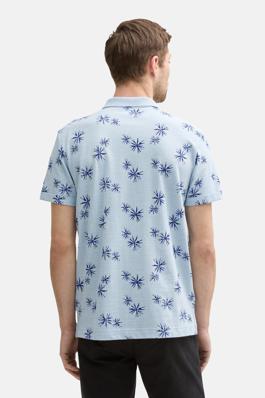 Blauwe polo met grafische print van Tom Tailor, rugdetail met blauw en zwart bloemenpatroon.