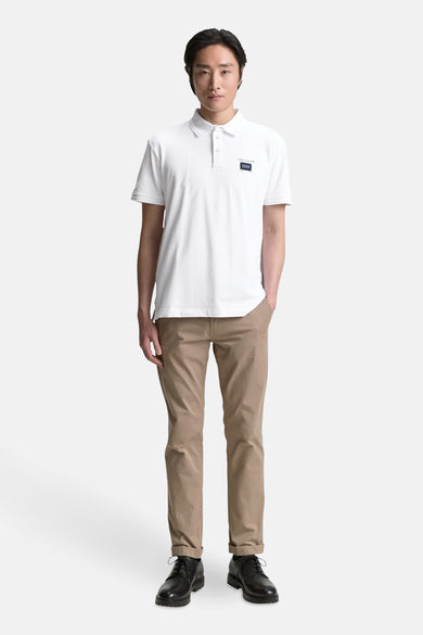 Wit poloshirt met korte mouwen van Tom Tailor, gedragen met een beige chino en zwarte schoenen.