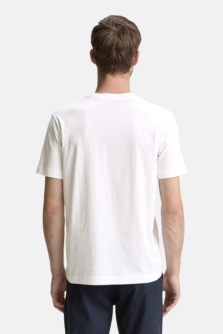 T-shirt blanc à manches courtes de Tom Tailor, porté avec un pantalon bleu marine, vue de dos.