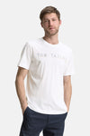 T-shirt blanc à manches courtes de Tom Tailor, avec logo graphique sur le devant, porté avec un pantalon bleu marine