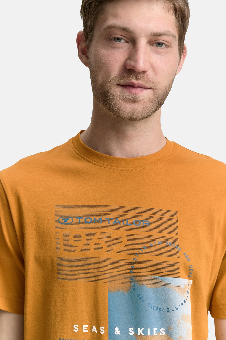 T-shirt à manches courtes ocre de Tom Tailor, avec un motif graphique « Seas & Skies » bleu et blanc.
