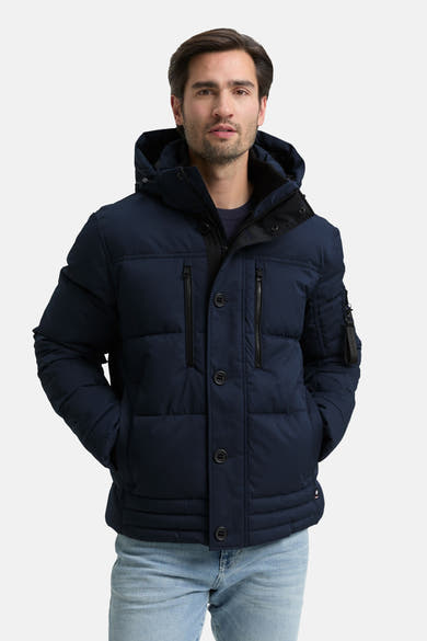 Veste courte bleue de Tom Tailor avec capuche et poches, portée avec un jean clair.