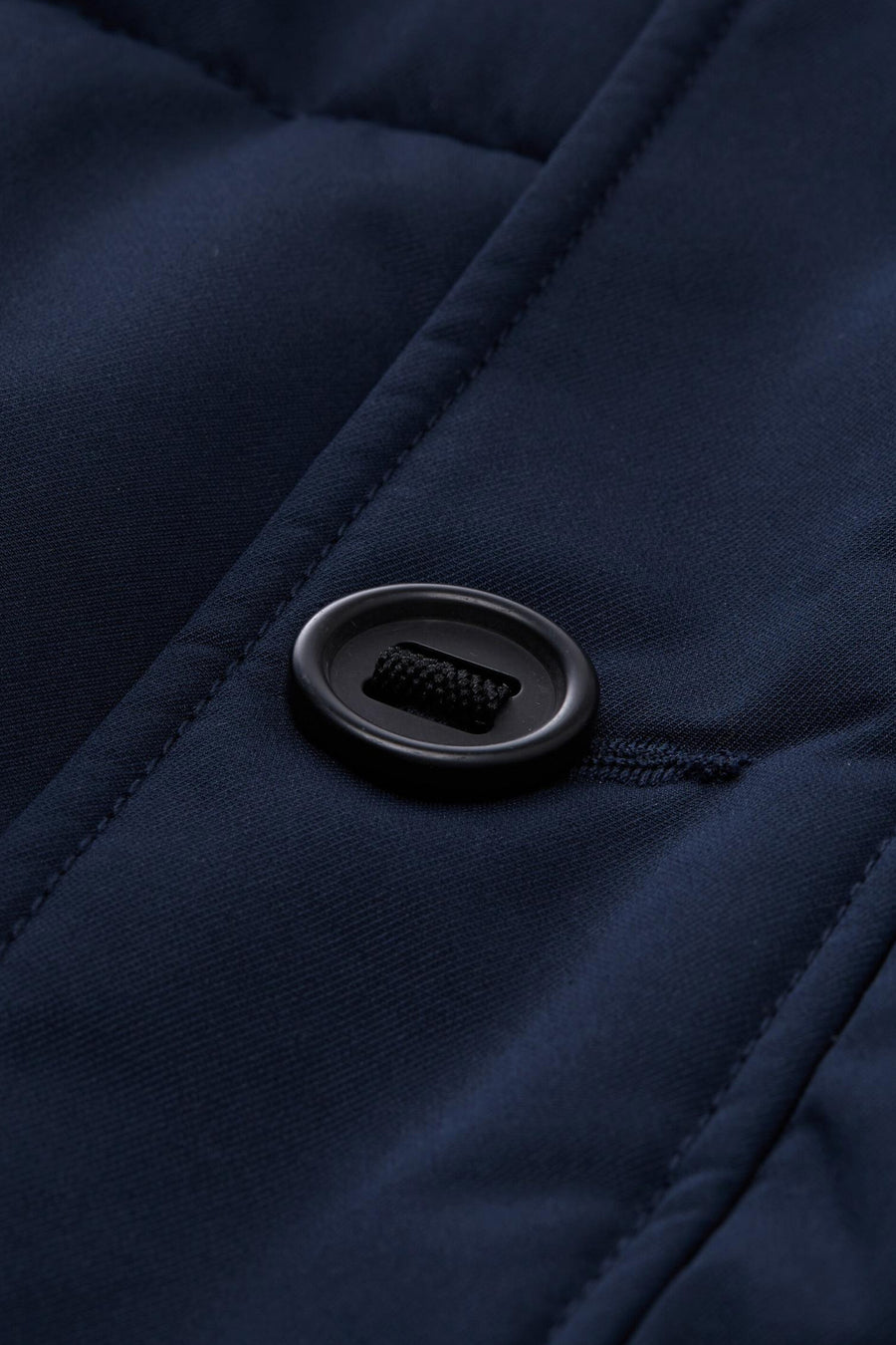 Veste courte bleue de Tom Tailor, avec fermeture boutonnée noire et détails matelassés.