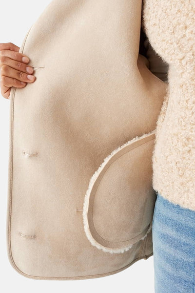 Veste courte beige d'OPUS, présentant une poche intérieure et une texture douce.
