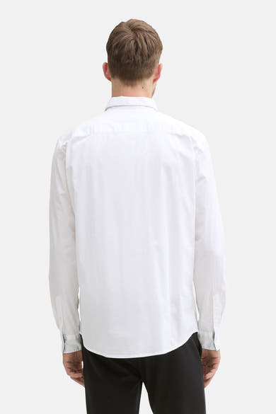 Wit overhemd met lange mouwen van Tom Tailor, van achteren gezien, met een zwarte broek.