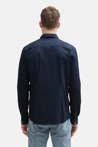 Donkerblauwe blouse met lange mouwen van Tom Tailor, van achteren gezien, gedragen met een spijkerbroek.