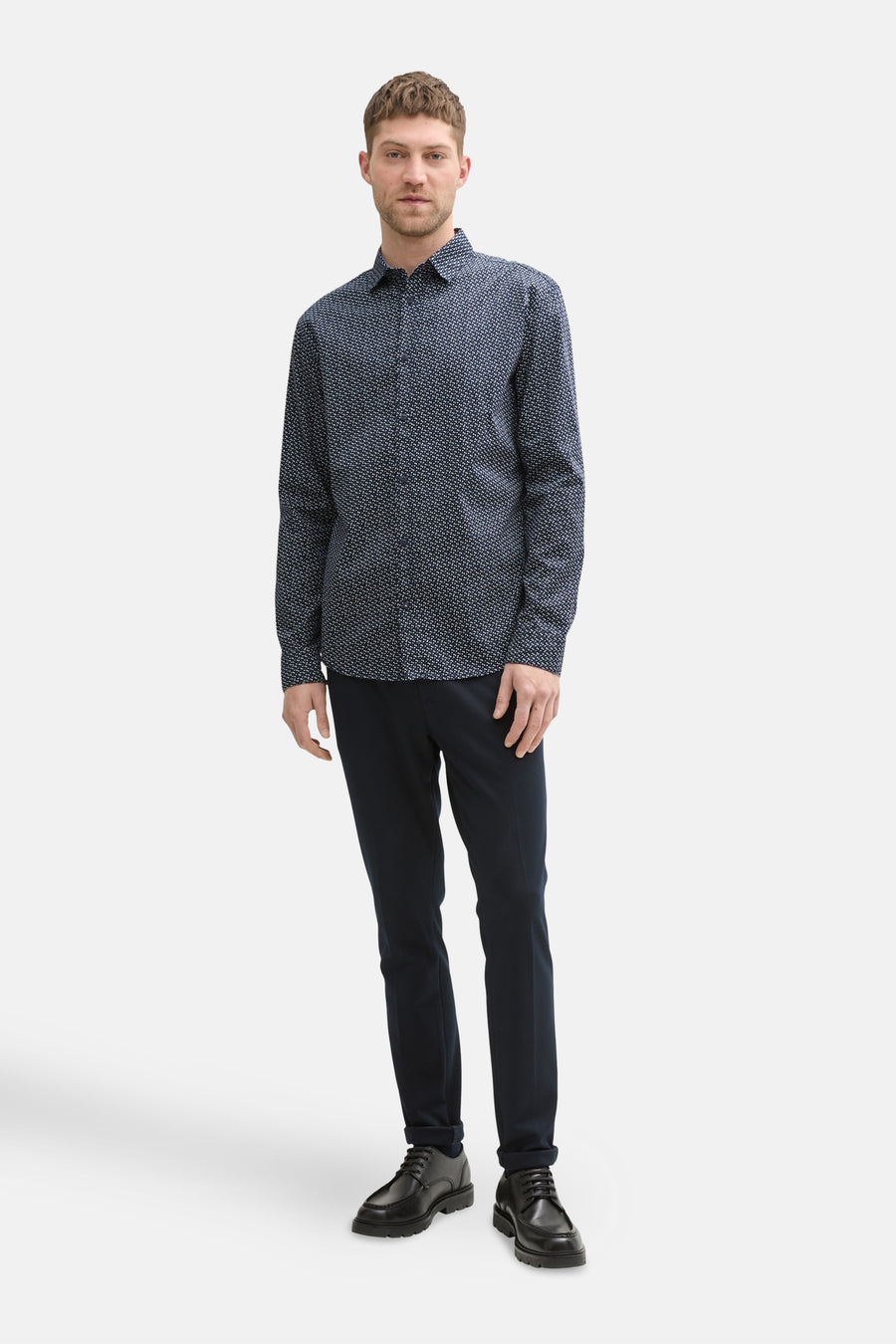 Chemise à manches longues bleue de Tom Tailor, à motifs, portée avec un pantalon et des chaussures noirs.