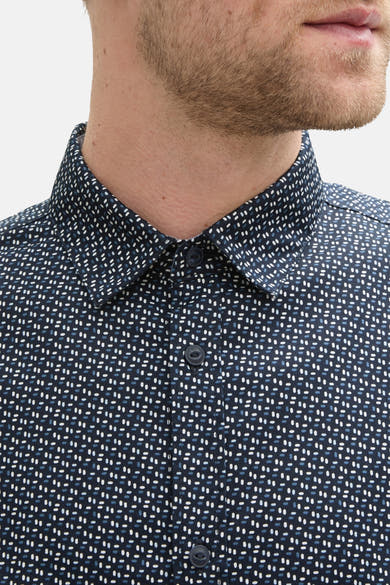 Chemise à manches longues bleue de Tom Tailor, avec un motif à pois blancs et bleus, visible sur le buste d'un homme.