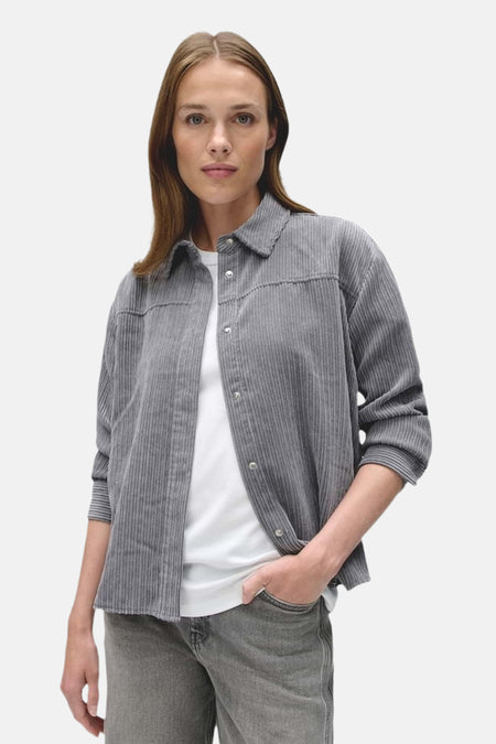 Chemise grise à manches longues OPUS, portée ouverte sur un T-shirt blanc.