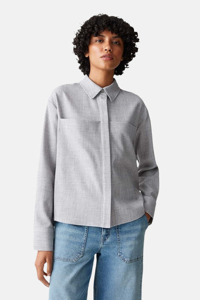 Chemise à manches longues grise d'OPUS, avec poches plaquées et manches longues, portée avec un jean bleu.