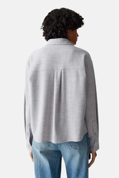 Chemise à manches longues grise de OPUS, avec pli creux au dos, portée avec un jean bleu.