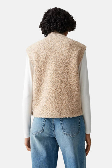 Pull écru à col rond de OPUS, porté avec un gilet en tricot beige et un jean bleu, vue de dos.