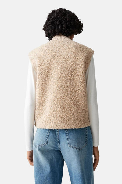 Pull écru à col rond de OPUS, porté avec un gilet en tricot beige et un jean bleu, vue de dos.