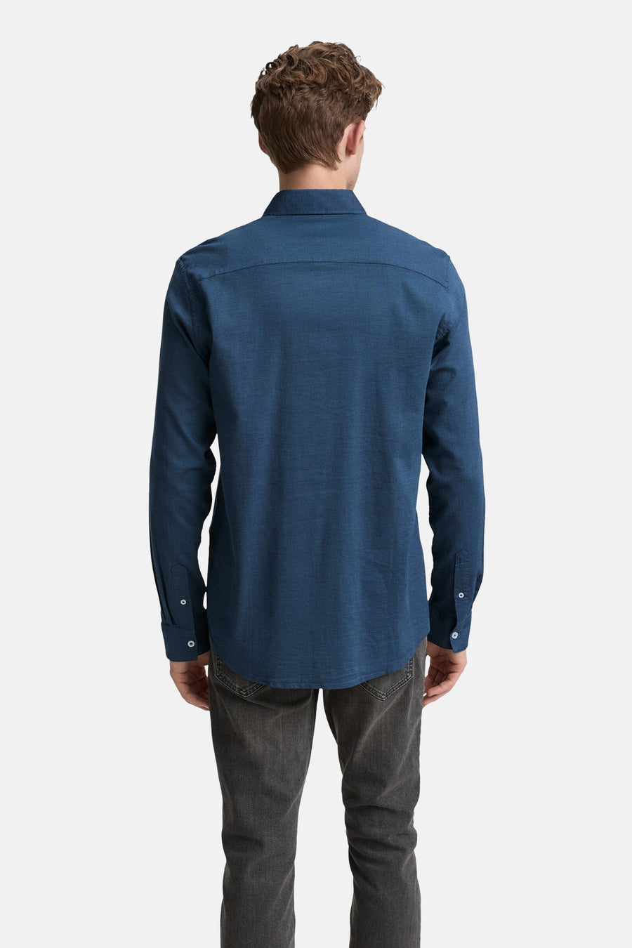 Blauw overhemd met lange mouwen van Tom Tailor, van achteren gezien, gedragen met een grijze broek.