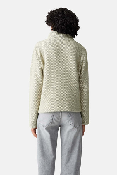 Pull vert texturé de OPUS, porté avec un jean gris ample, vue de dos.
