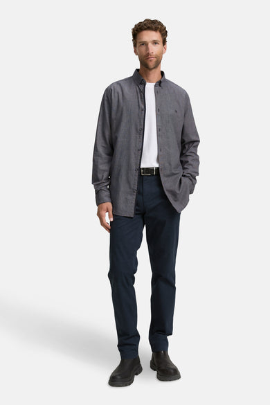 Blauw overhemd met lange mouwen van Tom Tailor, open gedragen over een wit T-shirt, met marineblauwe broek.