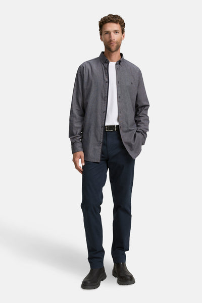 Blauw overhemd met lange mouwen van Tom Tailor, open gedragen over een wit T-shirt, met marineblauwe broek.