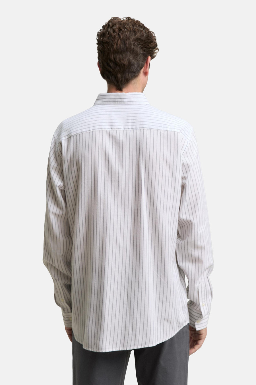 Wit gestreept overhemd met lange mouwen van Tom Tailor, van achteren gezien, gedragen met een donkergrijze broek.