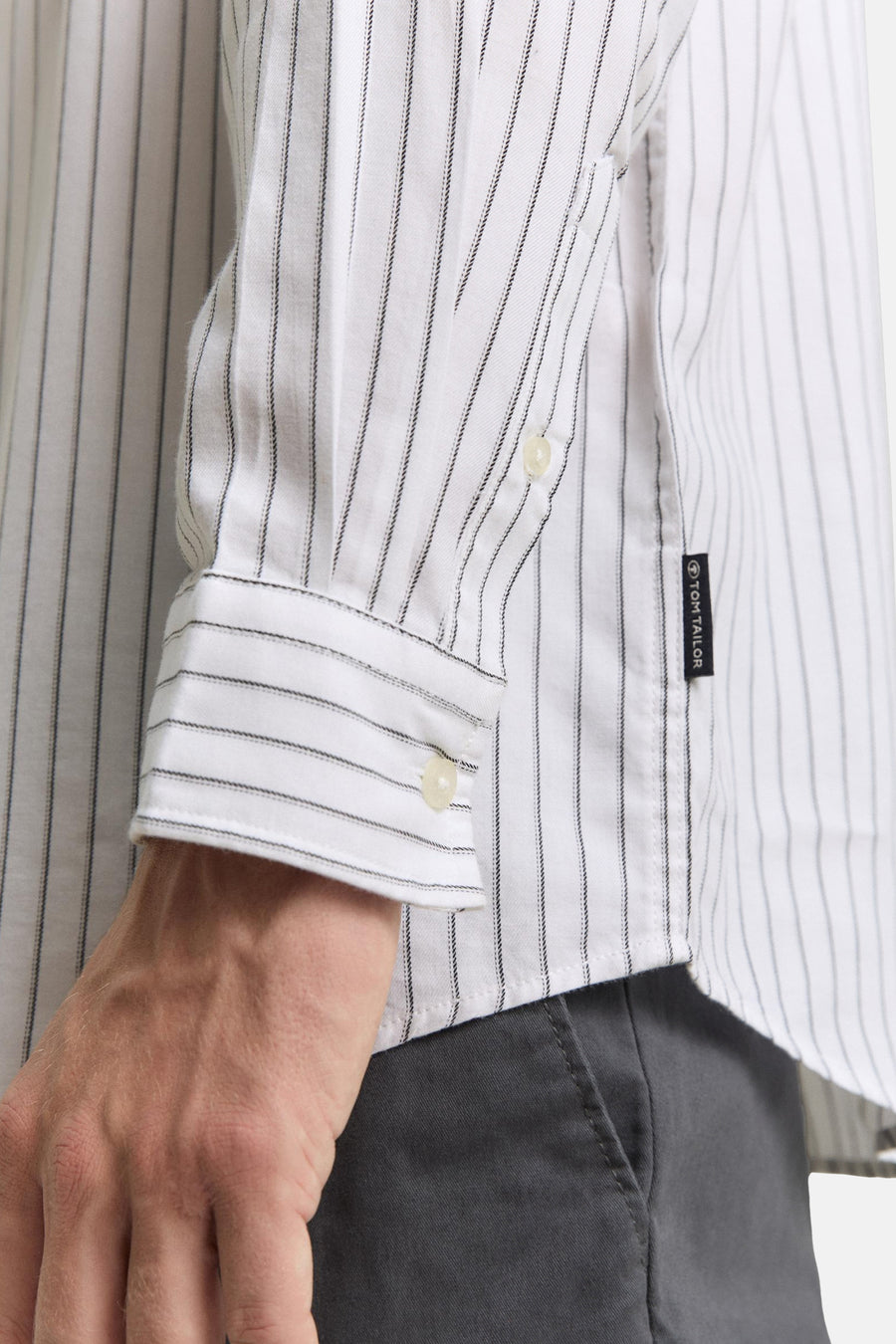 Wit gestreept overhemd van Tom Tailor, met knoopsluiting en manchet met knoop, gedragen met een grijze broek.
