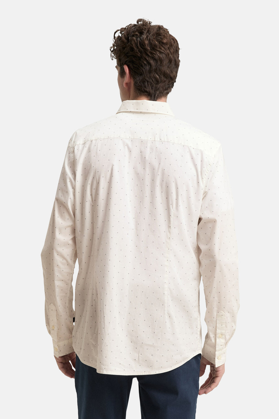 Ecru blouse met lange mouwen van Tom Tailor, met zwart stippenpatroon op een gebroken witte achtergrond.