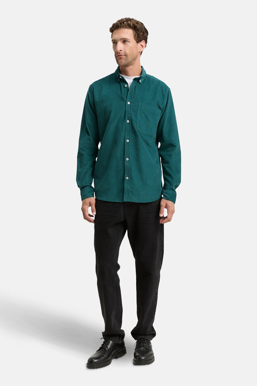 Groen fluwelen overhemd met lange mouwen van Tom Tailor, gedragen met een wit T-shirt en een zwarte broek.