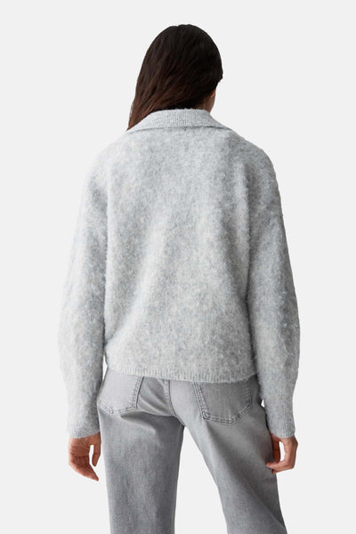 Pull gris par OPUS, avec une texture douce et porté avec un jean gris, vue de dos.
