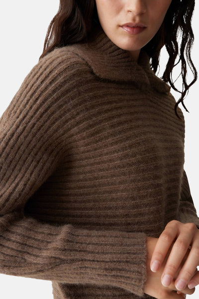 Pull brun en maille côtelée par OPUS, avec col montant et manches longues.