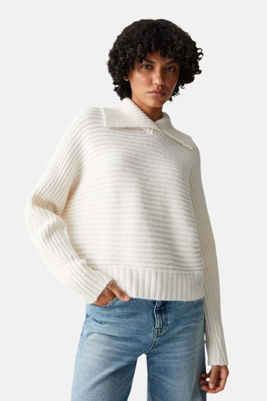 Pull beige côtelé van OPUS porté avec un jean bleu clair.
