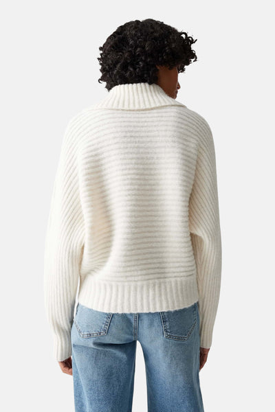 Pull beige en maille d'OPUS, avec col montant, porté avec un jean bleu, vue de dos.