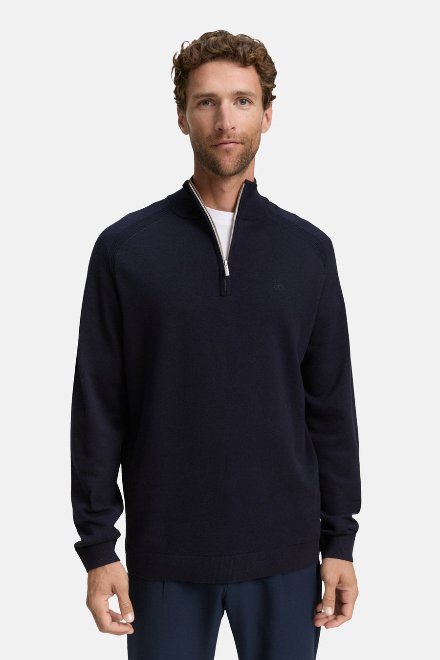 Pull à col rond bleu de Tom Tailor, avec fermeture éclair argentée et un t-shirt blanc visible.