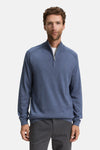 Blauwe trui met ronde hals van Tom Tailor, met gedeeltelijke ritssluiting en gedragen over een wit T-shirt.
