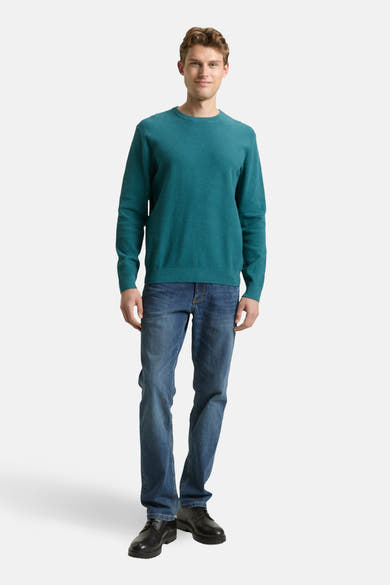 Pull à col rond vert de Tom Tailor, porté avec un jean bleu et des chaussures noires.