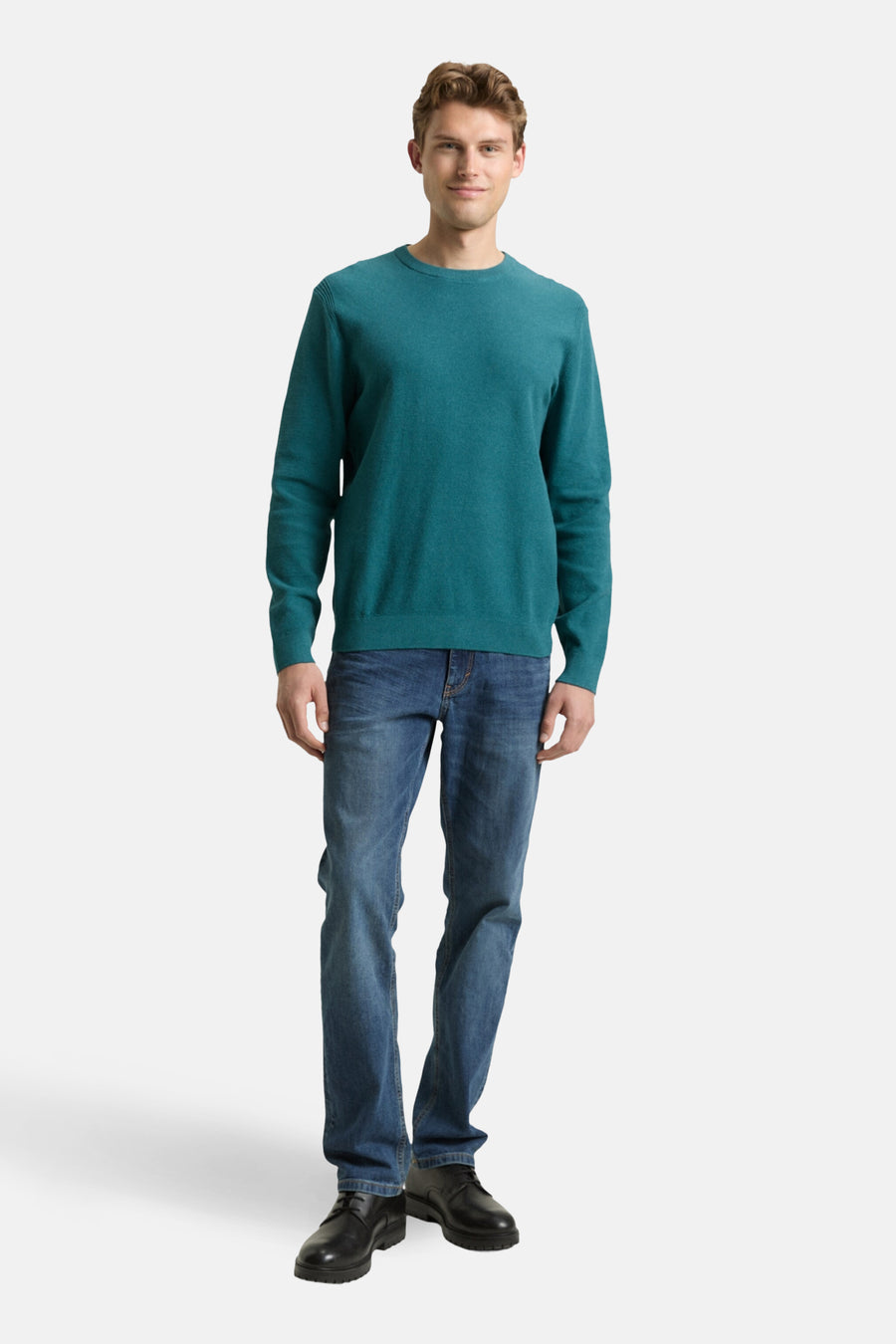 Pull à col rond vert de Tom Tailor, porté avec un jean bleu et des chaussures noires.