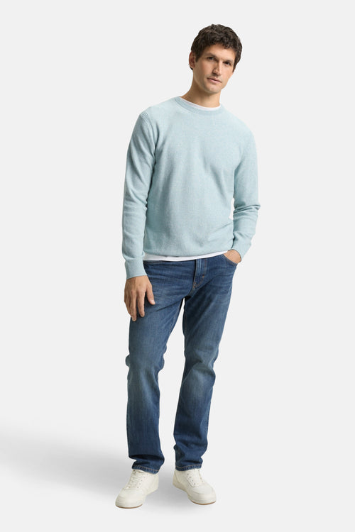 Pull à col rond bleu de Tom Tailor, porté avec un jean bleu et des baskets blanches.