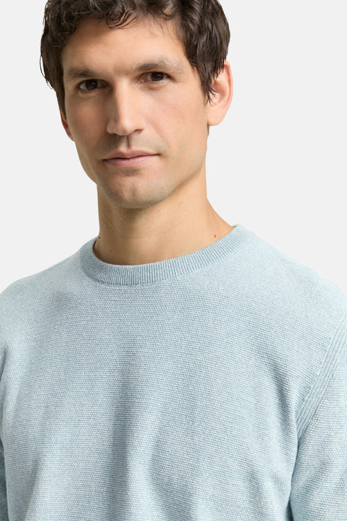 Ronde hals trui blauw van Tom Tailor, in een getextureerd breisel, gedragen door een man.