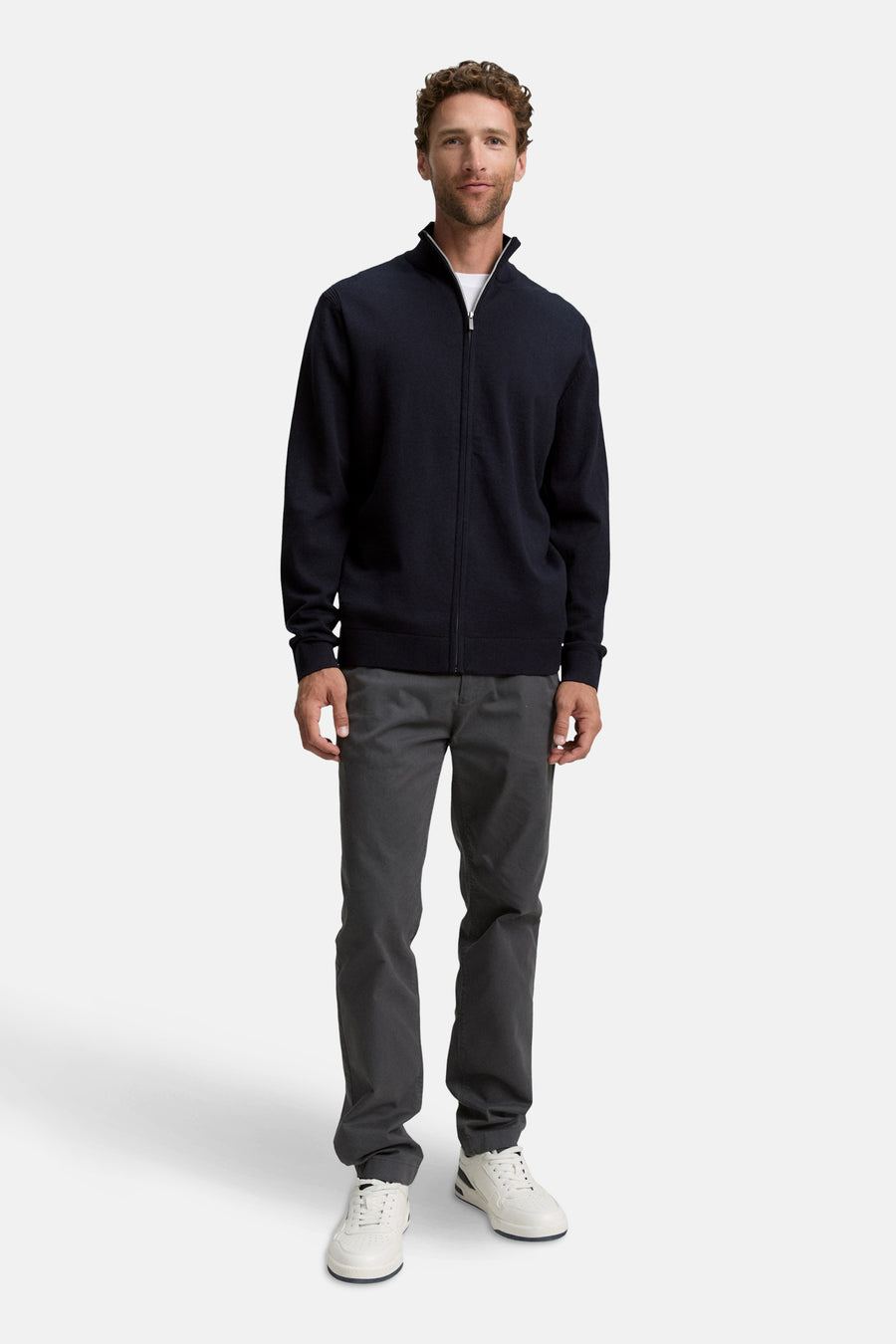 Gilet bleu par Tom Tailor porté avec un pantalon gris et des chaussures de sport blanches.