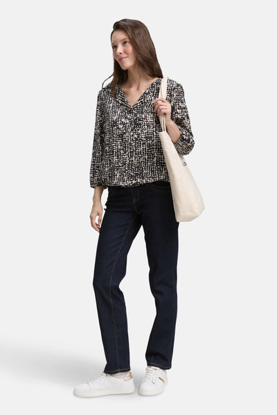Chemisier noir à motif de Tom Tailor, porté avec un jean et des baskets blanches, sac en toile sur l'épaule.