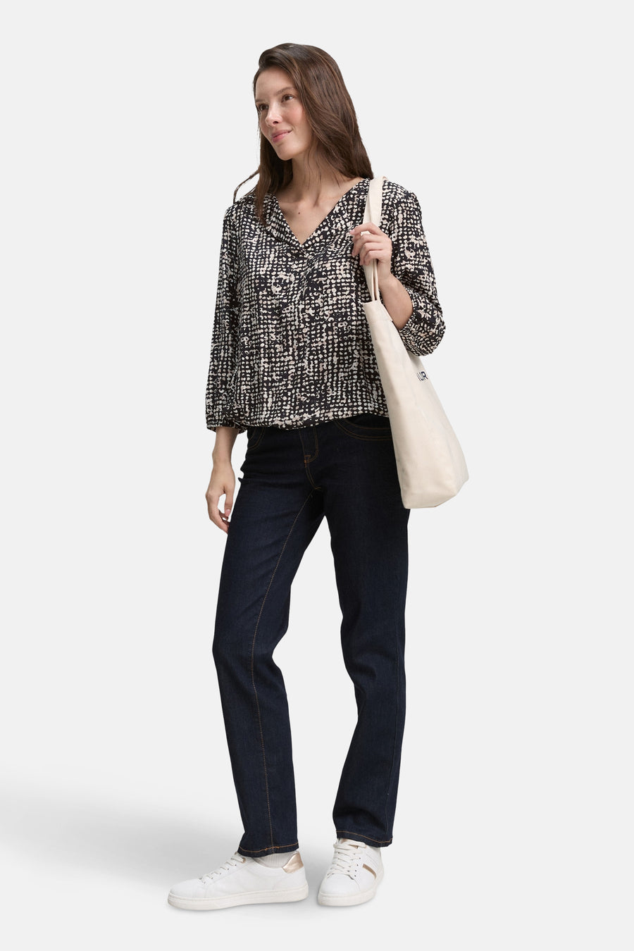 Chemisier noir à motif de Tom Tailor, porté avec un jean et des baskets blanches, sac en toile sur l'épaule.