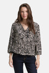 Blouse noire 3/4 de Tom Tailor, à motif géométrique all-over, portée avec un jean foncé.