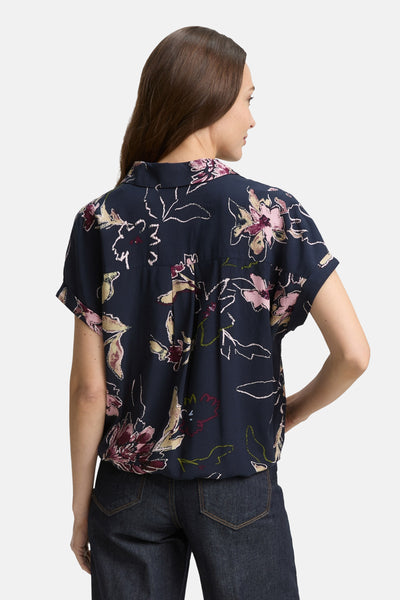 Chemisier à manches courtes multicolore de Tom Tailor, avec un motif floral et porté avec un jean foncé.

