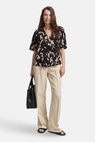Zwarte blouse met korte mouwen van Tom Tailor met abstract patroon gedragen met een wijde beige broek.