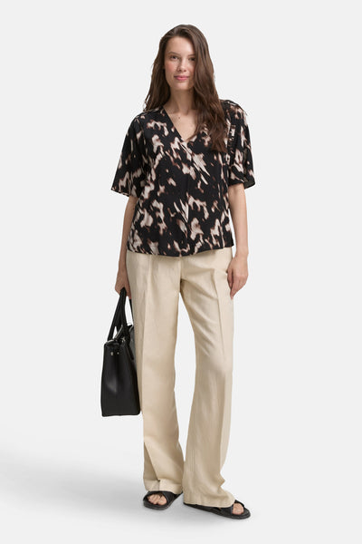 Zwarte blouse met korte mouwen van Tom Tailor met abstract patroon gedragen met een wijde beige broek.