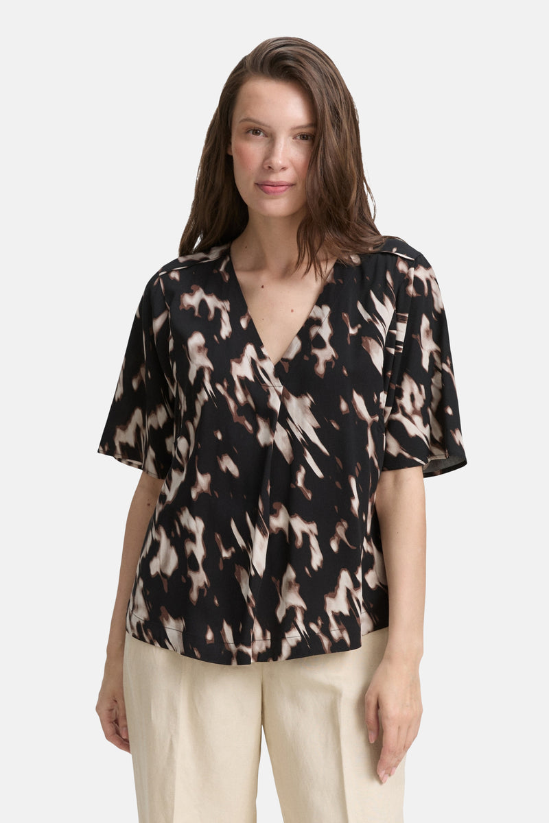 Zwart blouse met korte mouwen van Tom Tailor, met abstract patroon en V-hals, gedragen met een beige broek.