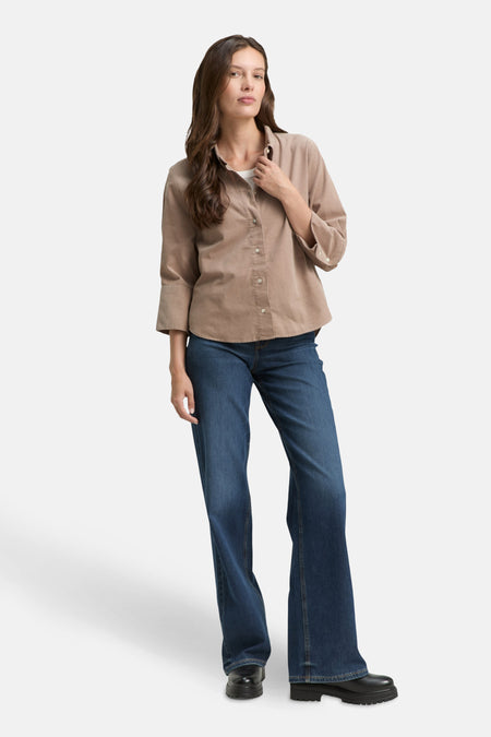Beige blouse met lange mouwen van Tom Tailor, gedragen met een blauwe jeans en zwarte schoenen.