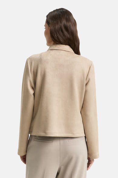 Veste courte beige en suède de Tom Tailor, vue de dos, portée avec un pantalon beige coordonné.