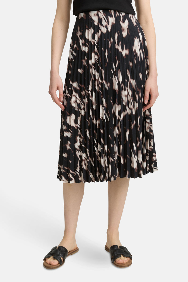 Lange meerkleurige rok van Tom Tailor, met abstracte gespikkelde print, halflange plooirok en platte sandalen.